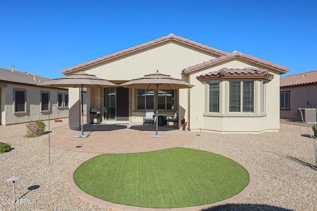 rear view of house featuring central AC unit and a patio area