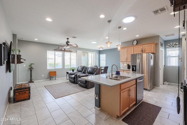 kitchen with light brown cabinets, ceiling fan, light tile patterned floors, an island with sink, and appliances with stainless steel finishes