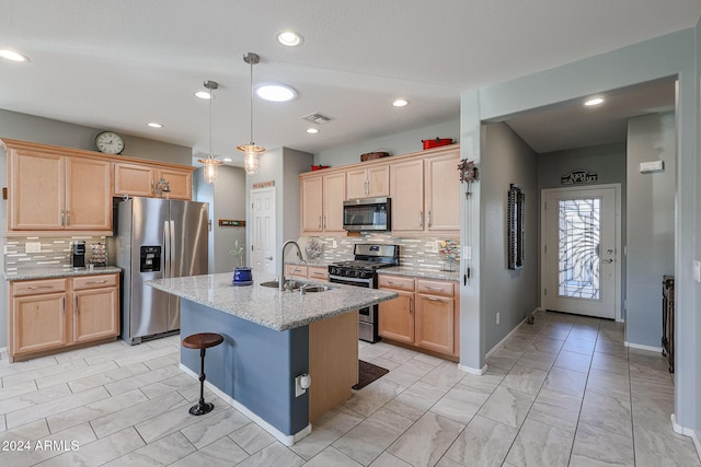 kitchen with backsplash, a center island with sink, sink, light stone counters, and stainless steel appliances