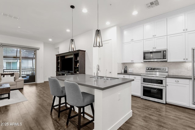6565 E Thomas Rd Unit 1096, Scottsdale, AZ 85251 - kitchen featuring appliances with stainless steel finishes, a sink, open floor plan, dark countertops, and recessed lighting
