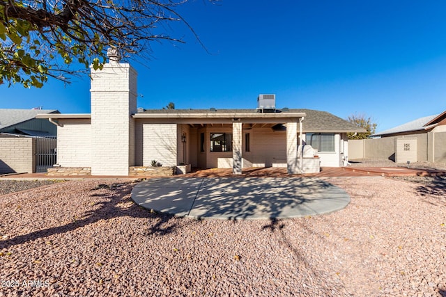 rear view of house featuring central AC unit and a patio