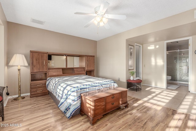 bedroom featuring light wood-style floors, visible vents, a textured ceiling, and baseboards