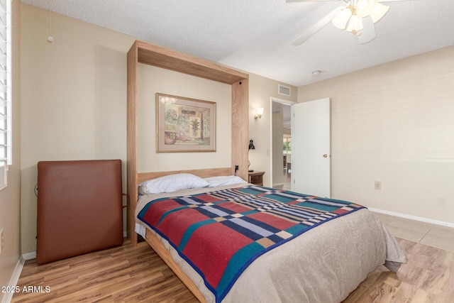 bedroom featuring a textured ceiling, wood finished floors, and visible vents