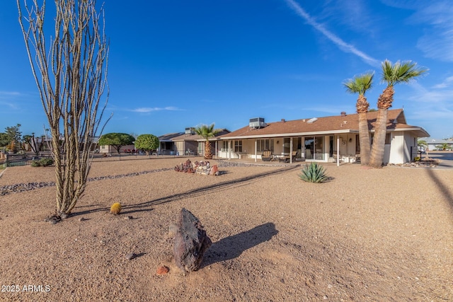 rear view of house with stucco siding, fence, and a patio