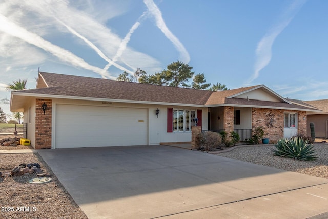 single story home featuring concrete driveway, brick siding, an attached garage, and a shingled roof