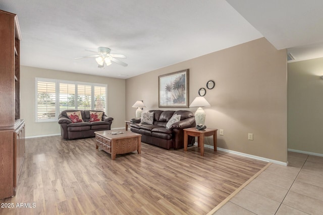 living room featuring a ceiling fan, light wood-style flooring, and baseboards