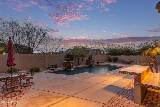 view of pool with outdoor dining area, a patio, and a fenced backyard