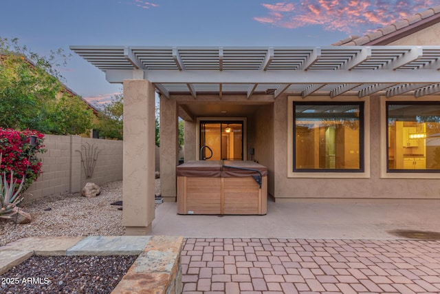 view of patio / terrace featuring a pergola, a hot tub, and fence