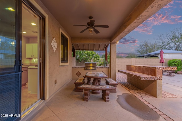 view of patio / terrace with a grill, exterior kitchen, ceiling fan, and fence