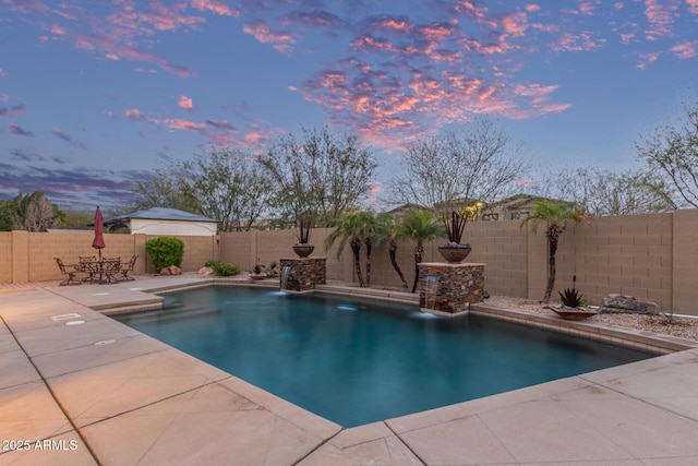 pool at dusk with a fenced backyard, outdoor dining space, a fenced in pool, and a patio