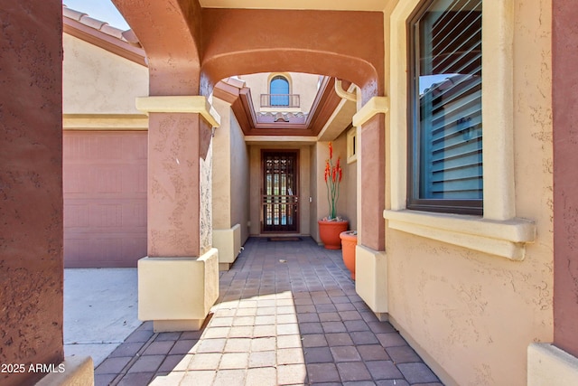 view of exterior entry featuring stucco siding and an attached garage