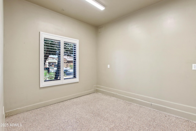 carpeted spare room featuring baseboards