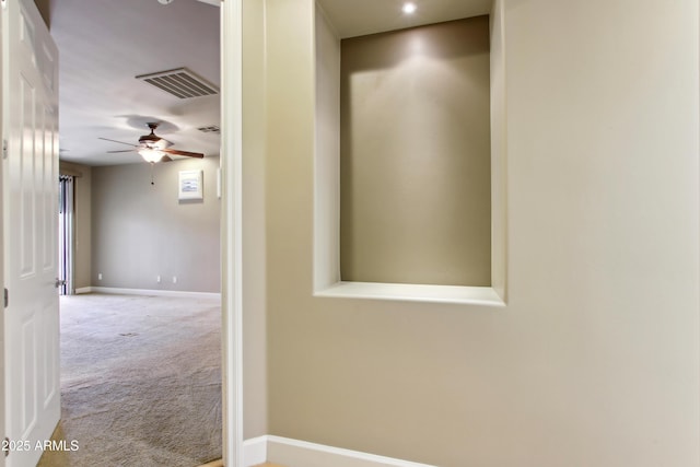 corridor featuring carpet, visible vents, and baseboards