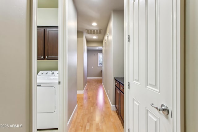 hall with visible vents, washer / clothes dryer, baseboards, and light wood-style flooring