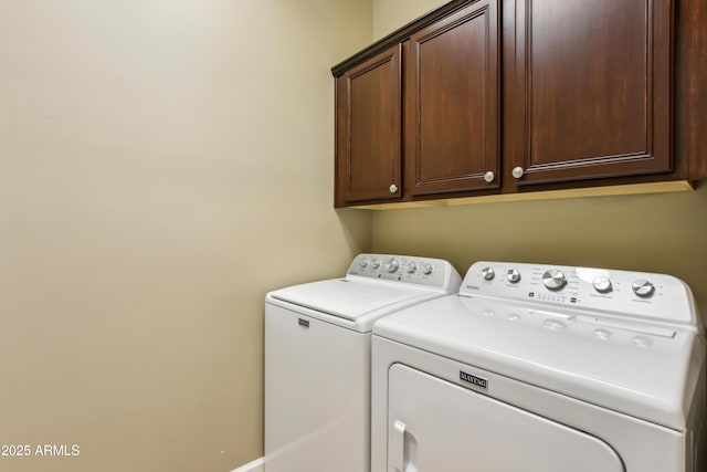 laundry room featuring washing machine and dryer and cabinet space