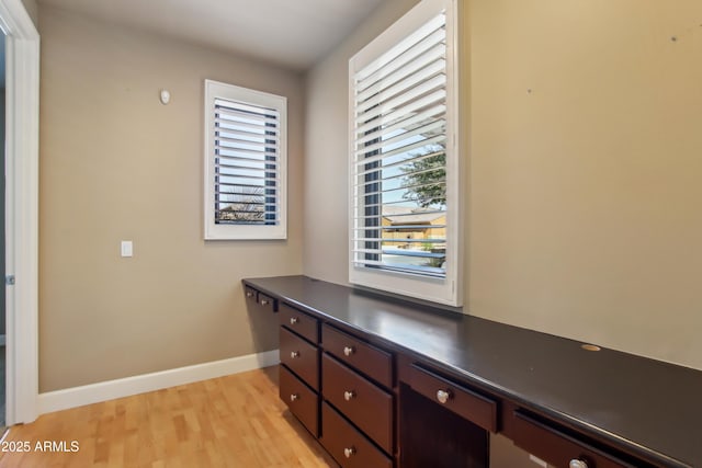 home office with baseboards and light wood finished floors