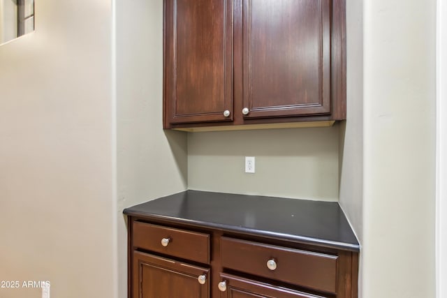 interior space with dark countertops and dark brown cabinets