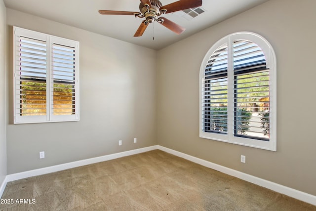 spare room featuring visible vents, carpet flooring, a healthy amount of sunlight, and baseboards