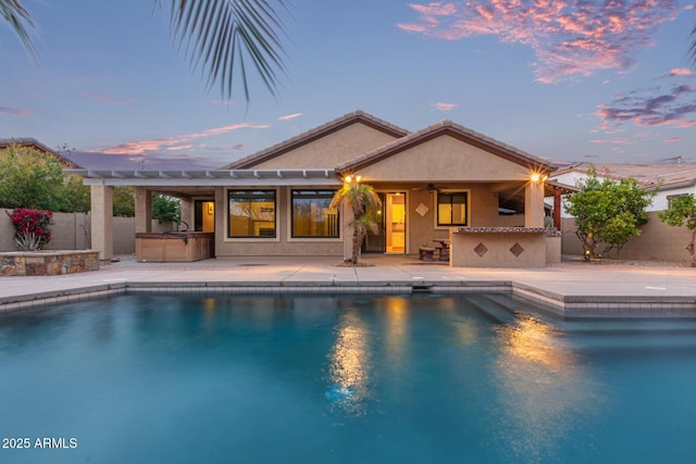 pool at dusk with a patio, a ceiling fan, a fenced backyard, a hot tub, and outdoor dry bar