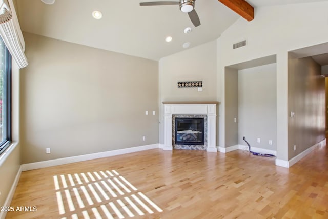 unfurnished living room with beam ceiling, light wood-style flooring, visible vents, and a high end fireplace