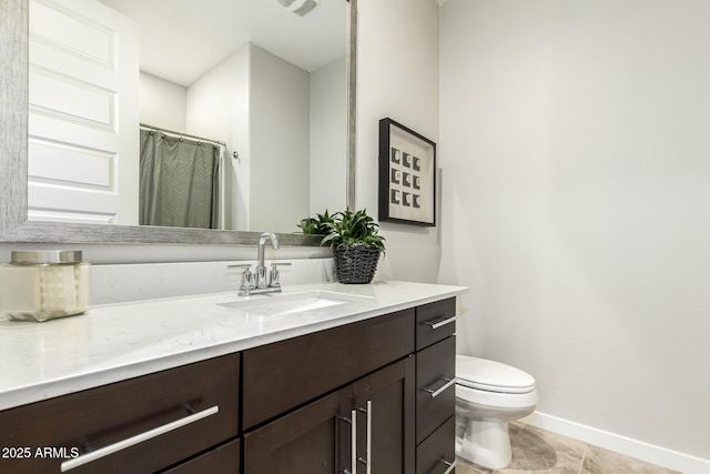 bathroom featuring tile patterned floors, vanity, and toilet