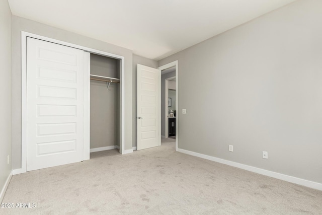 unfurnished bedroom featuring light carpet and a closet