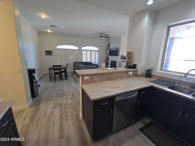 kitchen featuring stainless steel dishwasher, light wood-type flooring, and kitchen peninsula