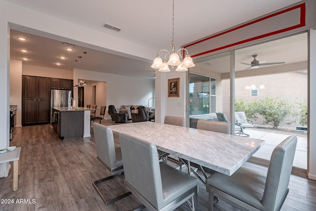 dining room with dark hardwood / wood-style floors, sink, and ceiling fan with notable chandelier