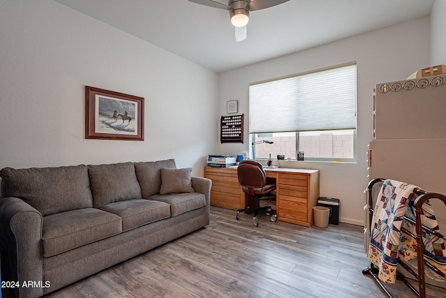 home office with light hardwood / wood-style floors and ceiling fan