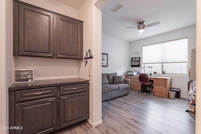 home office with built in desk, light hardwood / wood-style floors, and ceiling fan