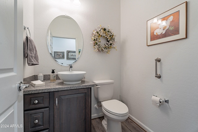 bathroom with vanity, hardwood / wood-style flooring, and toilet