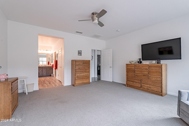 bedroom featuring connected bathroom, ceiling fan, and light colored carpet