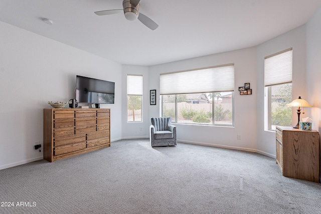 living area with light carpet and ceiling fan