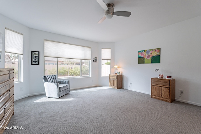 living area with light carpet and ceiling fan