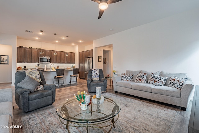 living room with ceiling fan and light wood-type flooring