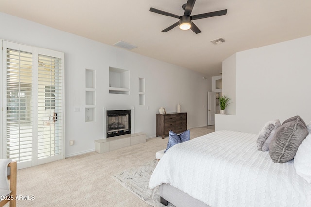 bedroom featuring visible vents, a tiled fireplace, carpet, and access to exterior