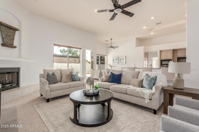 living area featuring visible vents, a fireplace, ceiling fan, recessed lighting, and light colored carpet