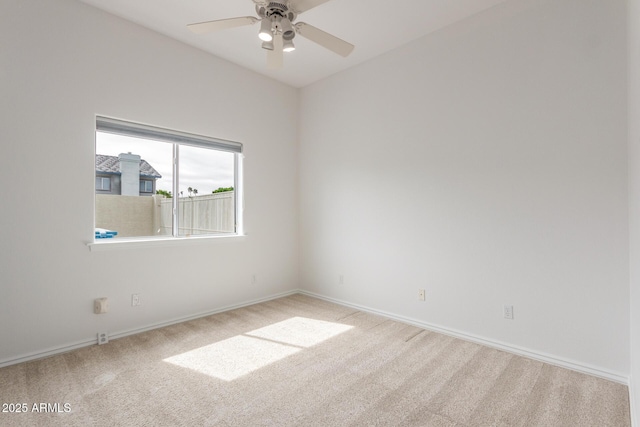 empty room featuring carpet floors, baseboards, and a ceiling fan