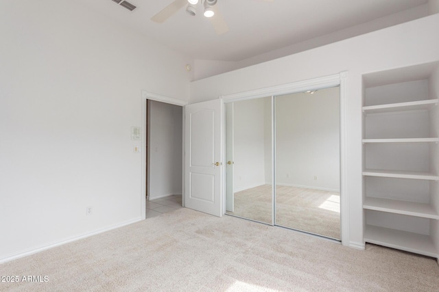 unfurnished bedroom featuring carpet floors, visible vents, a closet, baseboards, and ceiling fan
