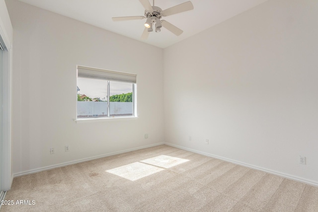 spare room featuring baseboards, a ceiling fan, and carpet