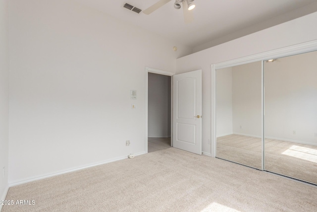 unfurnished bedroom with visible vents, a closet, baseboards, ceiling fan, and carpet
