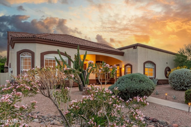 view of front of home with a tile roof and stucco siding