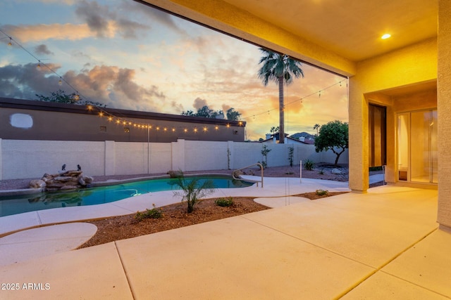pool at dusk with a fenced backyard, a fenced in pool, and a patio