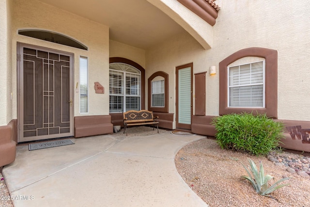 doorway to property featuring stucco siding
