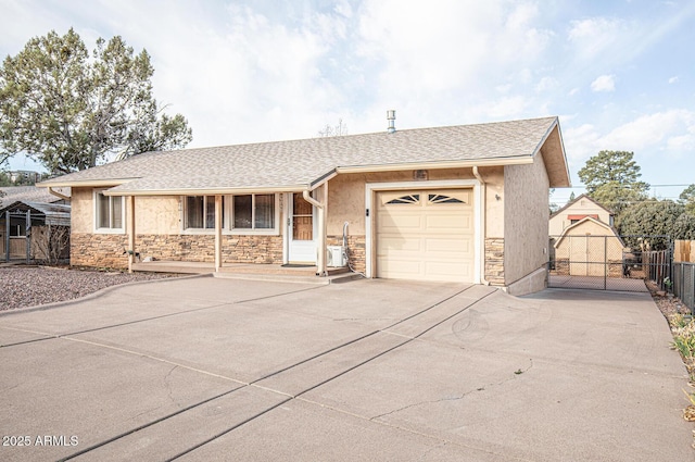 single story home with stone siding, driveway, an attached garage, and fence