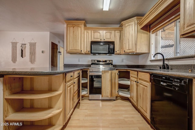 kitchen featuring light wood-style flooring, open shelves, a sink, black appliances, and dark countertops