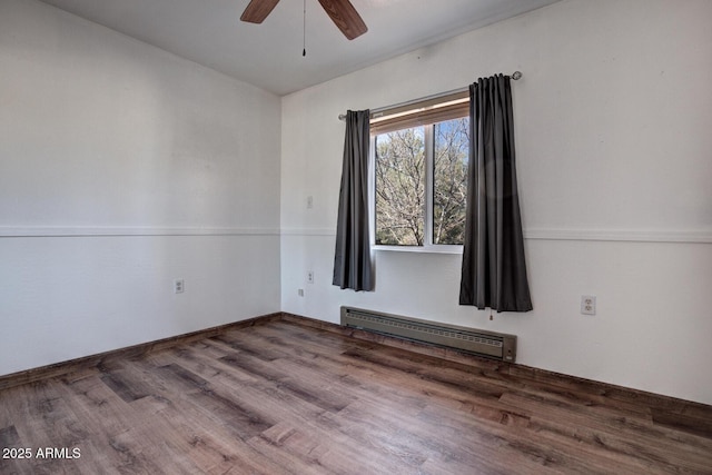 spare room with a ceiling fan, baseboard heating, and wood finished floors