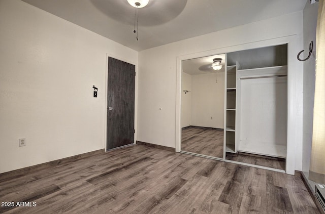 unfurnished bedroom featuring a closet, a ceiling fan, and wood finished floors