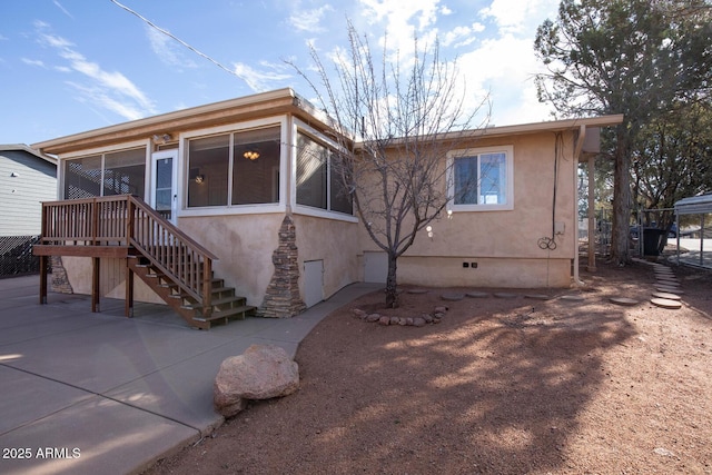 view of front of home with stairs, crawl space, a sunroom, and stucco siding