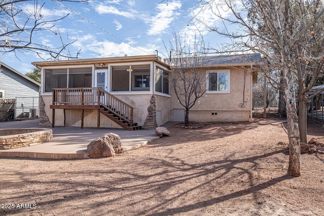 view of front of property featuring a patio, a sunroom, stairway, crawl space, and stucco siding